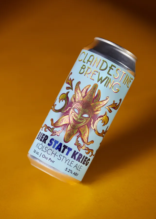 Can of Clandestine Brewing Bier Statt Krieg Kölsch-style ale with a jester mask label on a yellow background