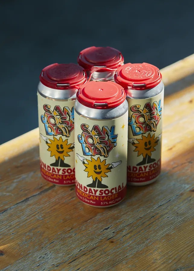 Four-pack of Clandestine Brewing Sunday Social Mexican Lager cans for San Jose Day on a wooden table